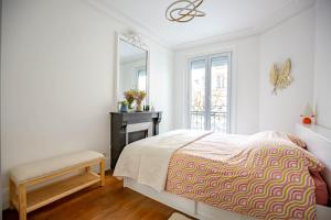 een slaapkamer met een bed, een tafel en een spiegel bij Paris naturellement in Parijs