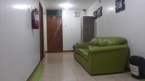 een groene bank in een kamer met een deur bij Sierra Verde - Muy Céntrico Hs in Huancayo