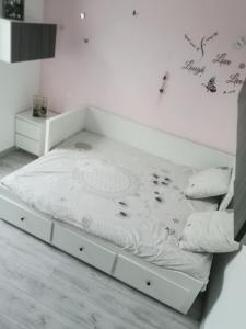 Cama blanca en habitación con marco de cama en Location 24H Le Mans, en Marigné-Laillé