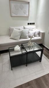 استوديو أنيق بحي حطين في الرياض: غرفة معيشة مع أريكة وطاولة قهوة زجاجية