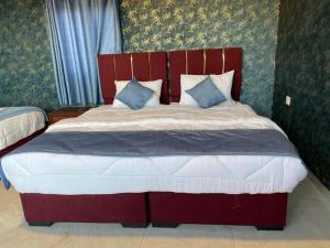 a bedroom with a large bed with a red headboard at Star Walk Camp & Tours in Wadi Rum