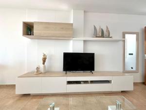 a living room with a television on a white wall at V015 - Marina Park in Roses +31 photos