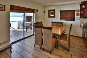 a dining room with a wooden table and chairs at Dalene se Seehuis, Langebaan, 8-sleeper in Langebaan
