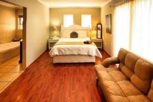 a bedroom with a bed and a couch and a tub at Dalene se Seehuis, Langebaan, 8-sleeper in Langebaan