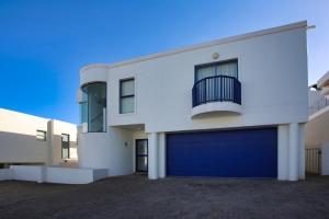 a large white building with a blue garage door at Dalene se Seehuis, Langebaan, 8-sleeper in Langebaan