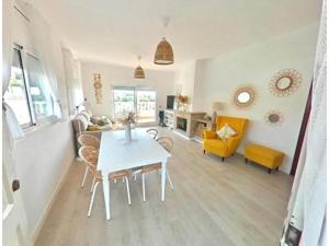 a living room with a table and a yellow chair at Casa con piscina de 8-14 personas in Calafell