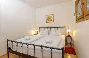 een slaapkamer met een bed met witte lakens en kussens bij Appartement Alpenresort by Schladming-Appartements in Schladming