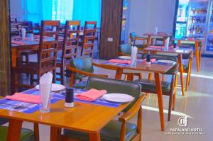 uma sala de jantar com mesas e cadeiras de madeira em Nefaland Hotel em Dar es Salaam