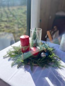 a table with a christmas centerpiece with a candle and christmas decorations at House in mountains, near Batumi- Lemanor Lodge in Kʼveda Chʼkhutunetʼi