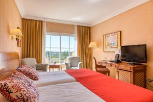 a hotel room with a bed and a television at Hotel Cordial Mogán Playa in Puerto de Mogán