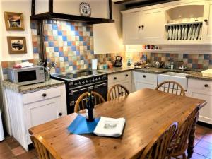 a kitchen with a wooden table and a kitchen with a stove at 3 Bed in Eskdale SZ416 in Santon Bridge