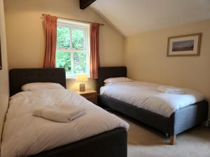 two beds in a room with a window at 3 Bed in Eskdale SZ416 in Santon Bridge
