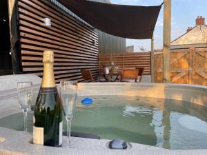 a bottle of champagne and two glasses next to a swimming pool at 2 bed in Cardigan 83919 in Cilgerran