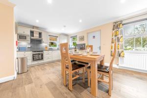 a kitchen with a wooden table and chairs at Summerbank Cottage, luxury Lake District holiday home in Coniston in Coniston