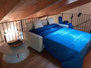 Un dormitorio con una cama azul y una mesa en BEST HOUSE, en Rávena