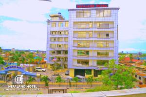 a tall white building with a sign on top of it at Nefaland Hotel in Dar es Salaam