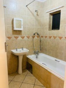a bathroom with a sink and a bath tub at The crib in Roodepoort