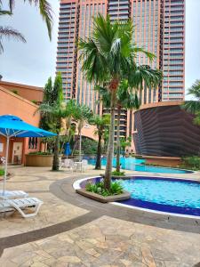 a resort pool with palm trees and buildings at Bukit Bintang Suite at Times Square KL in Kuala Lumpur