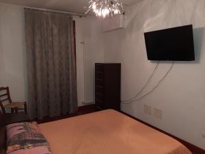 1 dormitorio con 1 cama y TV de pantalla plana en la pared en BEST HOUSE, en Rávena