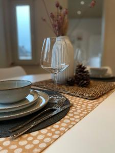 Cozy Appartement Hagen في هاغين: طاولة عليها أطباق وكأس النبيذ