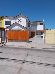 a white house with a orange fence on a street at Dpto interior nuevo, excelente ubicacion in Coquimbo