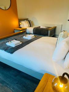 duas camas num quarto de hotel com toalhas em Caerau Heights em Newport