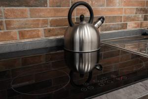 a metal tea kettle hanging on a brick wall at Urban Loft in Florence