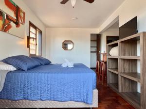 um quarto com uma cama azul em um quarto em Pousada Canajurê em Florianópolis mais 86 fotografias