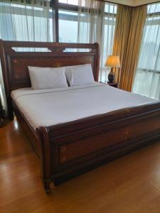 a large wooden bed in a room with windows at Bukit Bintang Suite at Times Square KL in Kuala Lumpur