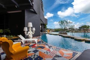 a pool at a hotel with chairs and a fountain at Arte Cheras by Sleepy Bear in Kuala Lumpur