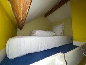 ein weißes Bett in einem Zimmer mit gelben Wänden in der Unterkunft Montmartre Sacré Cœur - Appartement Martyrs in Paris