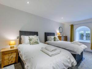a bedroom with two beds and a table with a lamp at 5 Bed in Barnstaple 85165 in Charles