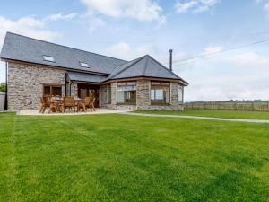 a stone house with a lawn in front of it at 5 Bed in Barnstaple 85165 in Charles