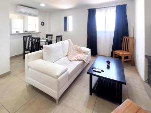 un soggiorno con divano bianco e tavolo di Rent for Days - Microcentro a San Miguel de Tucumán