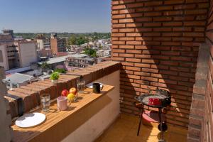 a balcony with a table on a brick wall at Rent for Days - Microcentro in San Miguel de Tucumán