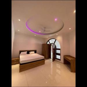 a bedroom with a bed with a purple ceiling at Mauji's Villa Hotel & Guest House in Prayagraj
