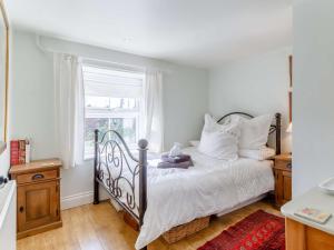 費肯漢的住宿－3 bed in Fakenham 85522，一间卧室配有一张带白色床单的床和一扇窗户。