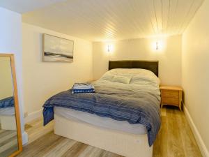 a small bedroom with a bed and a wooden floor at 2 Bed in Tenby 87912 in Tenby