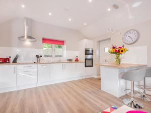 a kitchen with white cabinets and a clock on the wall at 1 Bed in Edenhall SZ604 in Edenhall