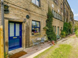 a blue door on a brick building with a table at 1 Bed in Holmfirth 85392 in Holmfirth