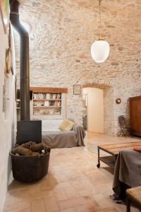 a living room with a bed and a fireplace at Can Feliu, Masia Stone House, Apartment and Ground-Floor apartment, Sant Daniel-Girona in Girona