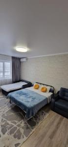 Habitación con 2 camas y una silla. en Mega Apart in Almaty en Almaty