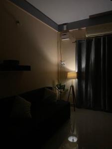 a dark room with a bed and a lamp at Keylo Homes in Arambol