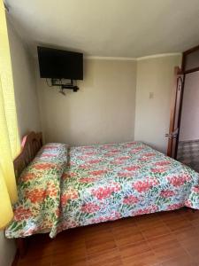 a bedroom with a bed with a colorful bedspread at Hostal Alborada in Cajamarca