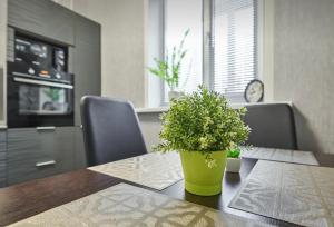 a dining room table with a green potted plant on it at VIP apart 703 in Tbilisi City