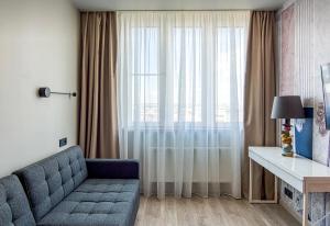 a living room with a couch and a large window at VIP apart 703 in Tbilisi City