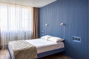 a bedroom with a bed and a blue striped wall at VIP apart 703 in Tbilisi City