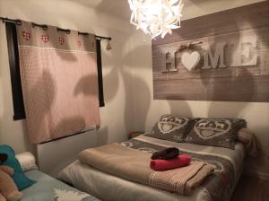 um quarto com uma cama e um lustre em Gîte - Appartement - sans draps et serviettes em Artigues