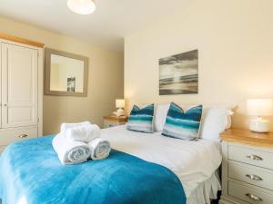a bedroom with a bed with blue and white pillows at 2 Bed in Croyde 87110 in Croyde