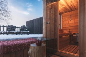 un porche de una cabaña de madera con mesa y bancos en Hotel Majerca, en Bohinj